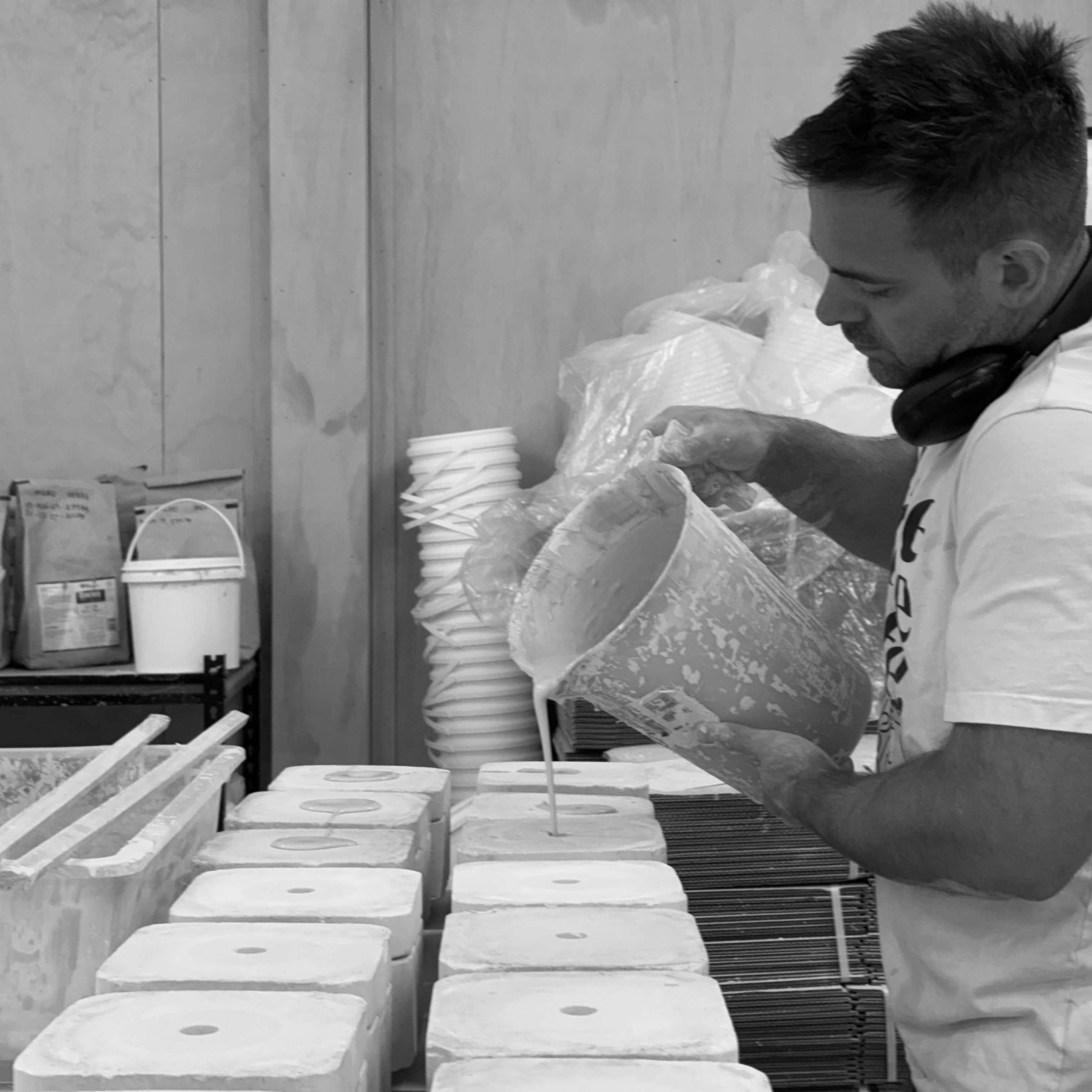 Sam Mayell pouring clay slip into plaster moulds in his ceramics studio.